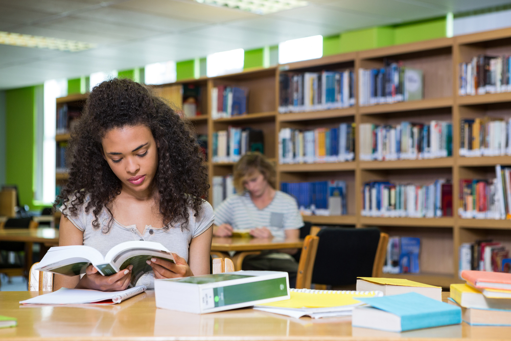 aluna estudando em biblioteca